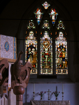 All Saints chapel, interior, church, dark, subdued, blue, stained glass, candlesticks, candles, cross, altar, lectern, eagle, West Dean, Westdean, East Sussex, England, Britain, UK, May 2007