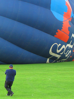 Crew man, crown line, hot air balloon, blue, inflating, launching, lawn, Leeds Castle, Kent, England, Britain, UK, May 2007